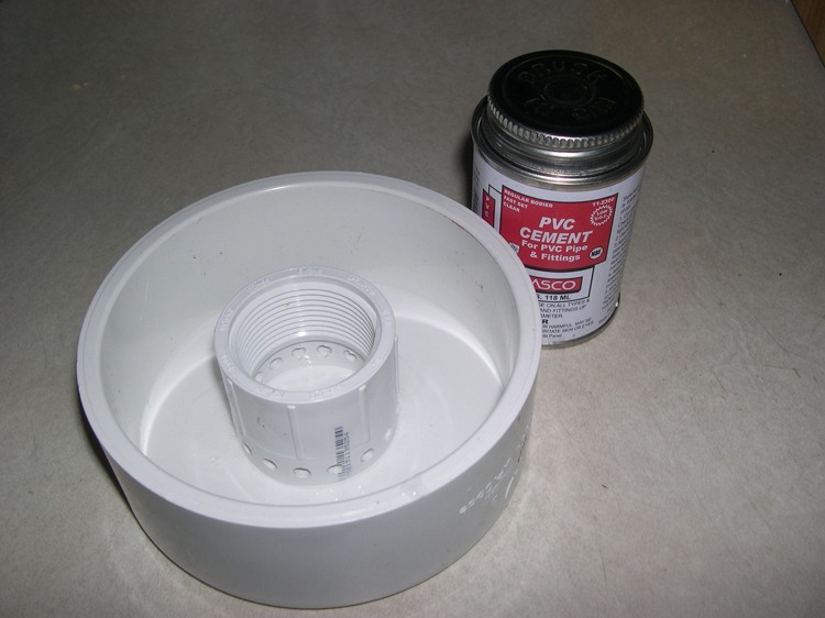 Photograph of coupling after gluing in position inside pipe cap, showing cement used for the purpose.