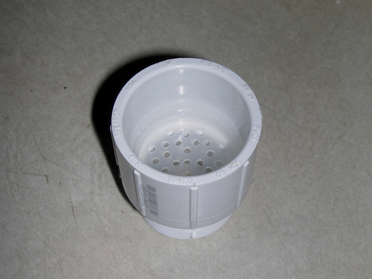 Filter in place inside the M/F coupling.  The small piece of PVC pipe will be cemented in on top of it, thus securing it in place.